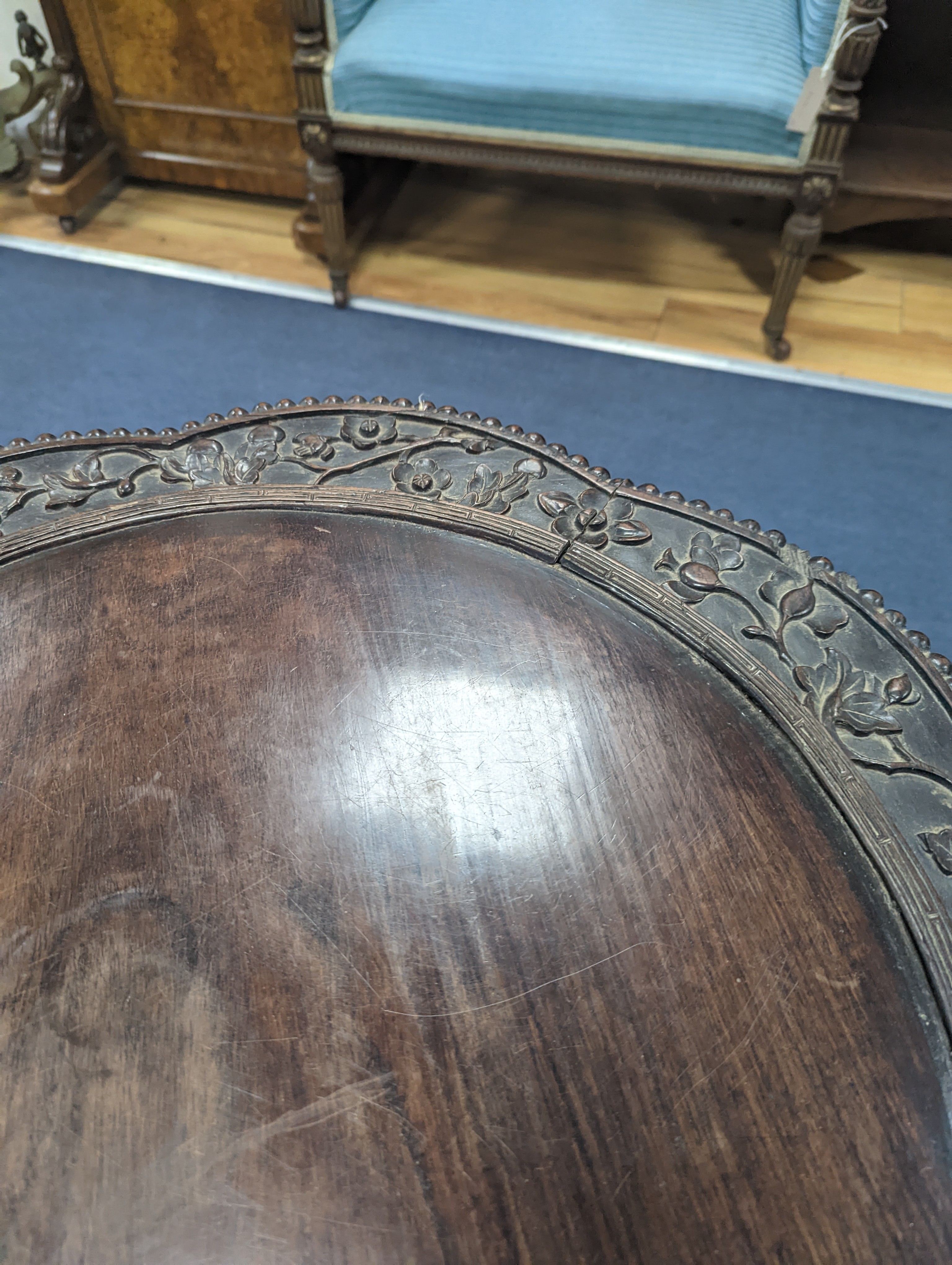 An early 20th century Chinese carved hardwood two tier table, diameter 64cm, height 56cm